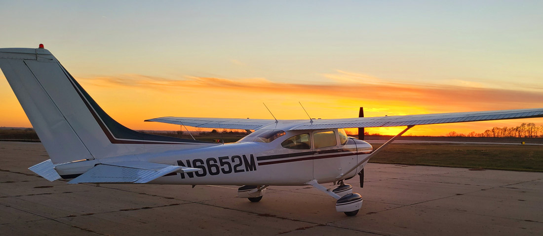 a small plane sitting on top of an airport during sunset