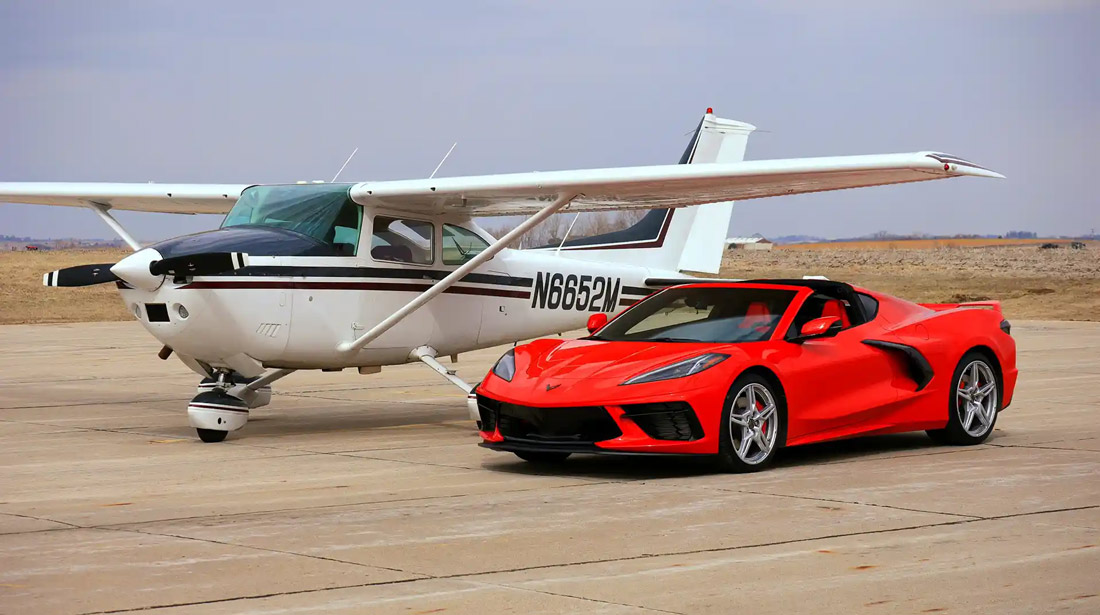 a white airplane and a red sports car