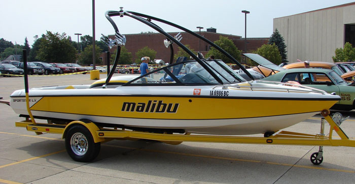 a yellow and white speed boat parked in a parking lot